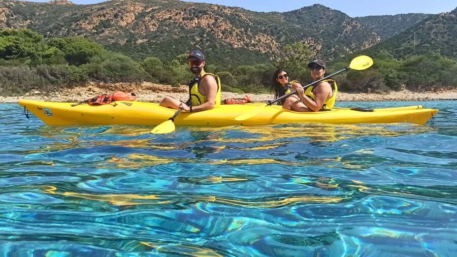 Chia: kayak tour to Tuerredda with snorkeling - Paddling past cliffs toward the Ferraglione islands